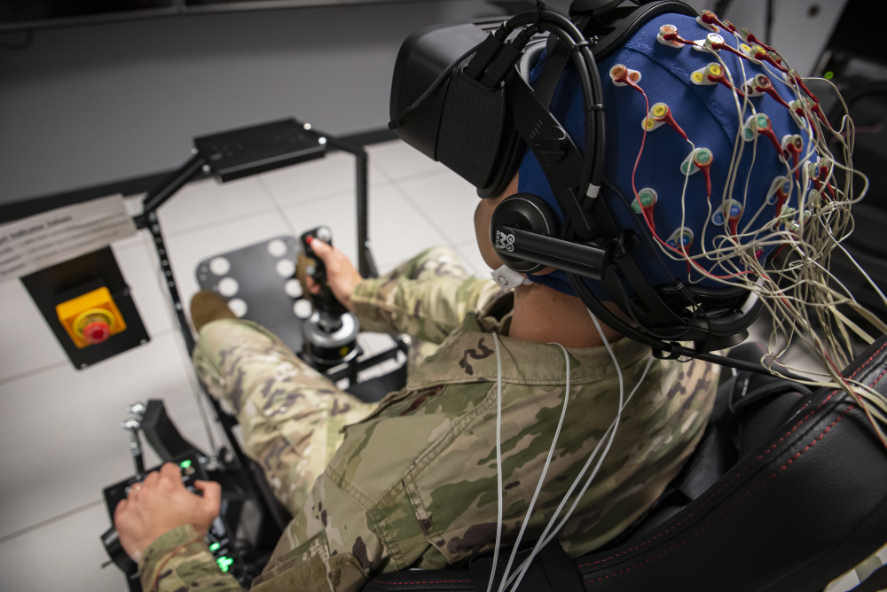 Man wearing virtual reality helmet with additional sensors attached to scalp.