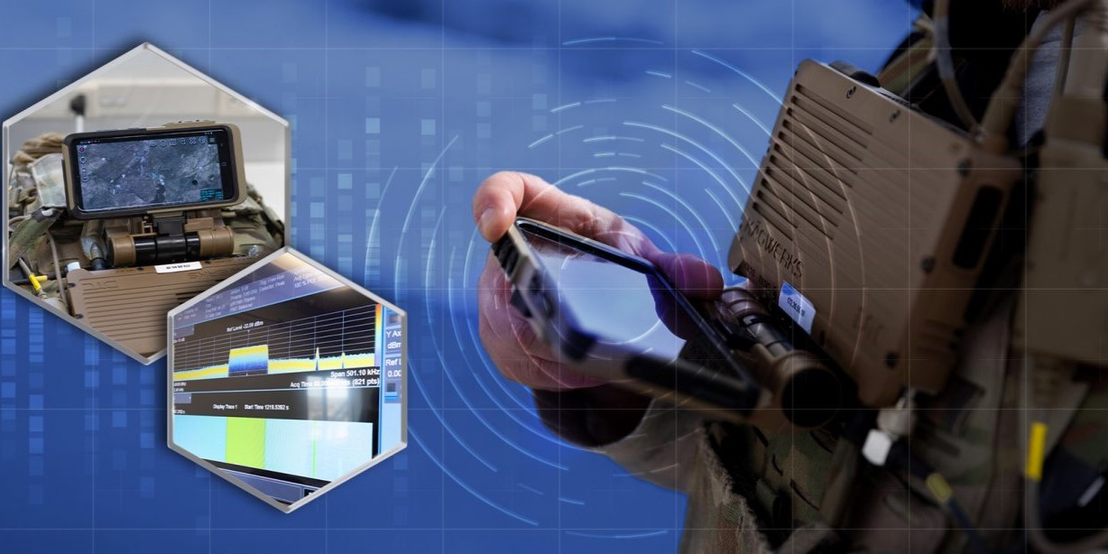closeup of soldier holding a communications device strapped to his chest