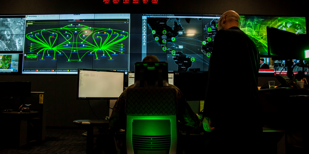 Cybersecurity personnel observing information on computer monitors