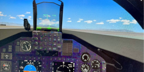 Shown is a T-45C prototype mixed reality cockpit view. Note: Dials, displays, and out-of-the-cockpit view are virtual images while the cockpit panels and buttons are seen in the “real world” via a video pass-through camera.