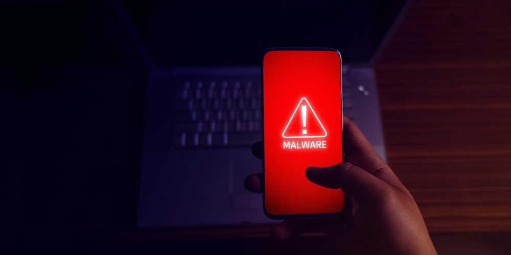 Source: Shutterstock, https://www.shutterstock.com/image-photo/anonymous-hacker-uses-malware-mobile-phone-1454959556